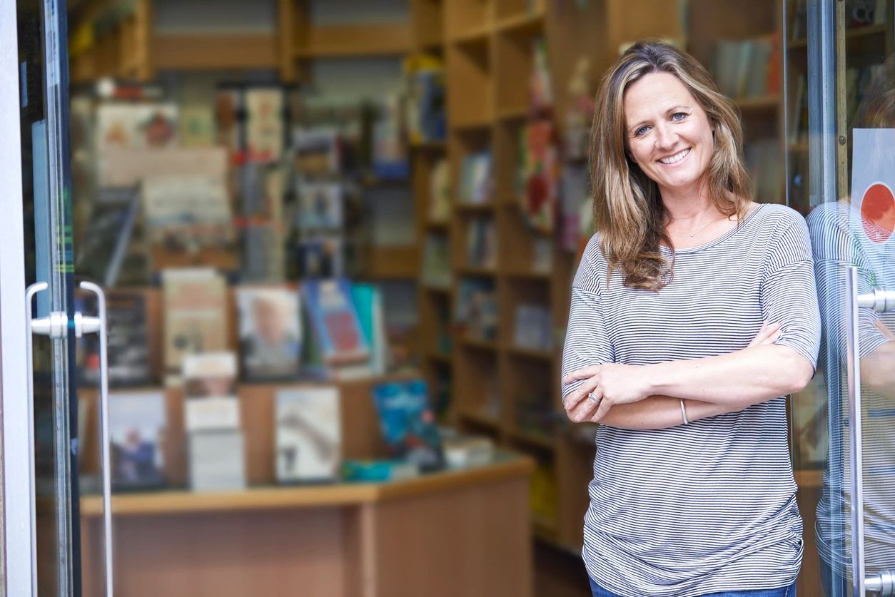 A woman standing in front of a book store.