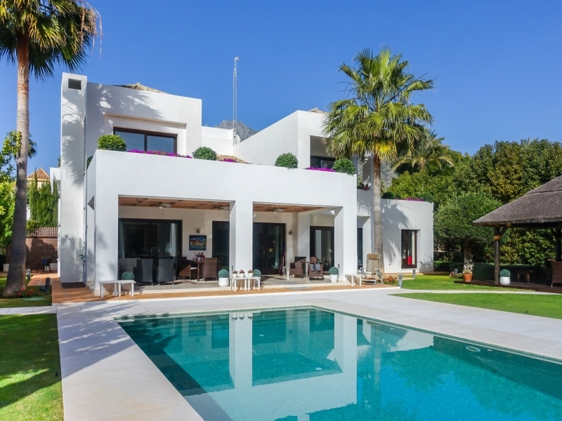 A large white house with a pool in the middle of it.