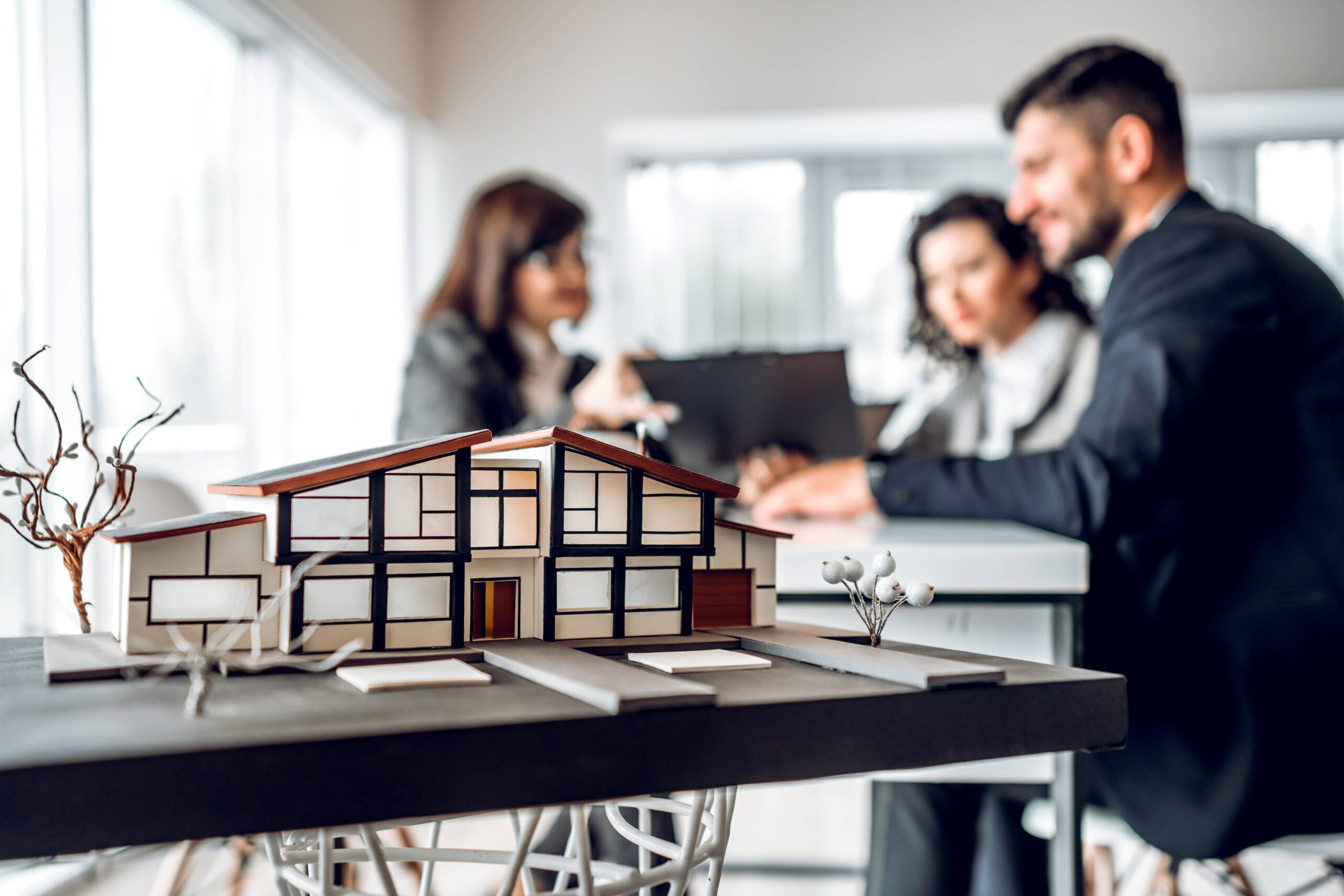 A group of people in an office with model houses.