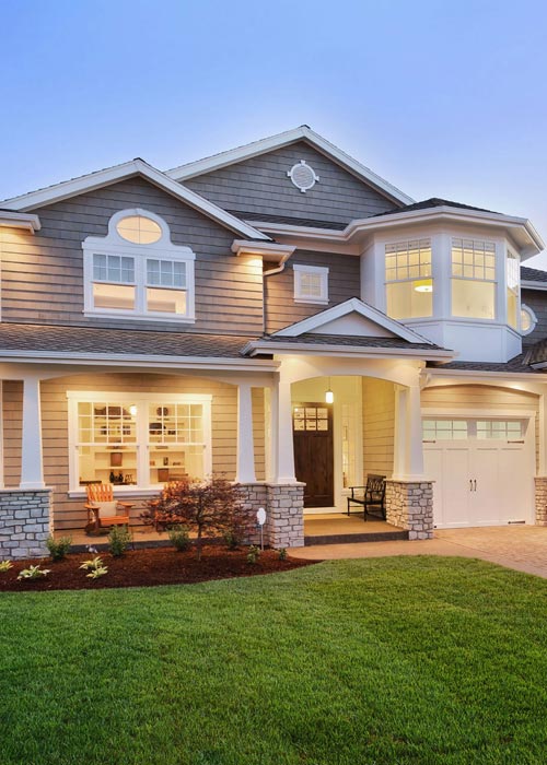 A house with a lawn and a garage door.